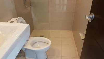 a bathroom with a white toilet and a sink at 11B Tower 1 Viceroy Residences Mc Kinley Hill BGC in Manila