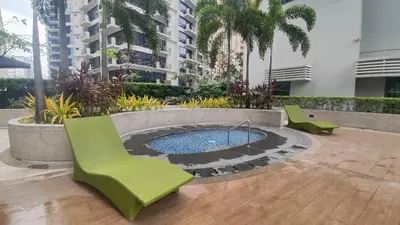 a patio with chairs and a pool in a building at 11B Tower 1 Viceroy Residences Mc Kinley Hill BGC in Manila