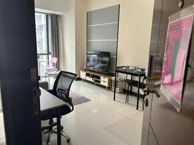 a room with a table and chairs and a television at 11C Tower 1 Viceroy Residences McKinley BGC in Manila