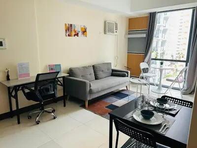 a living room with a couch and a table at 11C Tower 1 Viceroy Residences McKinley BGC in Manila