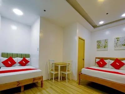 two beds in a room with a table and chairs at Freemont Place in Manila