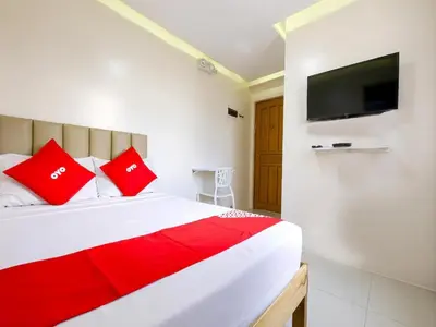 a bedroom with a bed with red pillows and a tv at Freemont Place in Manila