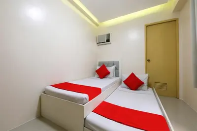 two beds in a room with red and white sheets at Freemont Place in Manila