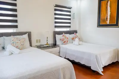 two beds sitting next to each other in a room at Teofely Gardens Resort near Tagaytay in Silang