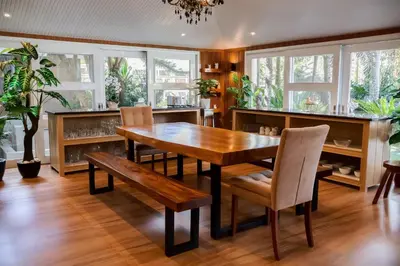a dining room with a wooden table and chairs at Teofely Gardens Resort near Tagaytay in Silang