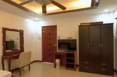 a living room with a tv and a cabinet and a mirror at Teofely Gardens Resort near Tagaytay in Silang