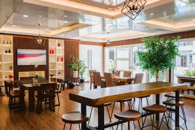 a dining room with tables and chairs and a tv at Teofely Gardens Resort near Tagaytay in Silang
