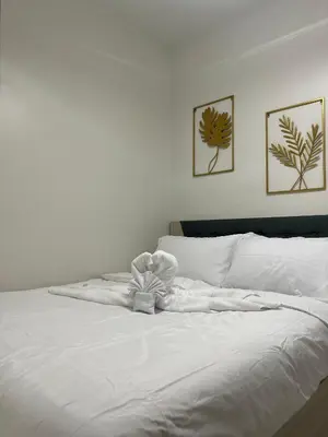a white bed with a teddy bear on it at Molly Shore Getaway Unit 1241 in Manila