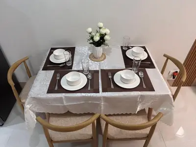 a dining table with a white tablecloth and a vase of flowers at Molly Shore Getaway Unit 1241 in Manila
