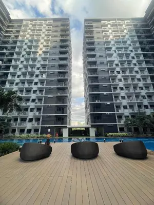 two tall buildings with benches in front of two buildings at Molly Shore Getaway Unit 1241 in Manila
