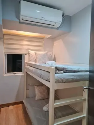 a room with two bunk beds and a ceiling fan at Cozy 2BR in BGC near golf course - B Fort TB in Manila