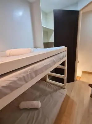 a bedroom with two bunk beds and a mirror at Cozy 2BR in BGC near golf course - B Fort TB in Manila