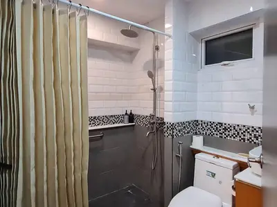 a bathroom with a shower and a toilet at Cozy 2BR in BGC near golf course - B Fort TB in Manila