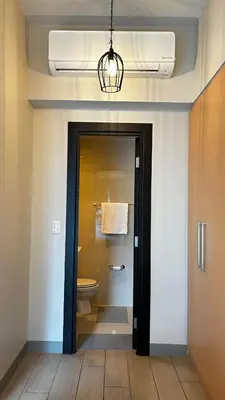 a bathroom with a toilet and a light at Uptown Parksuites Tower Two - BGC Taguig, Manila in Manila