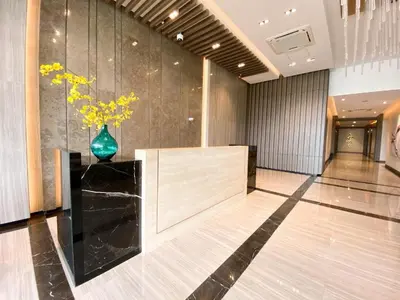 a lobby with a vase with yellow flowers in it at Uptown Parksuites Tower Two - BGC Taguig, Manila in Manila