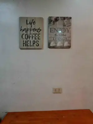two posters on a white wall with a wooden table at Matthew's Private Pool by Mia and Miguel's House in General Trias