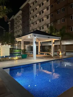 a swimming pool in front of a building at night at Athena's Place - Hope Residences SMDC Trece Cavite in Trece Martires