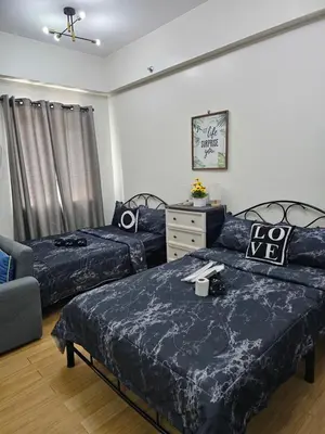 a bedroom with two beds and a dresser at Athena's Place - Hope Residences SMDC Trece Cavite in Trece Martires