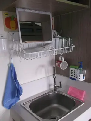 a kitchen sink with a microwave above it at Para Sa'yo in Manila