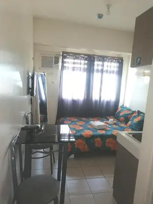 a room with a desk and a bed with a window at Para Sa'yo in Manila