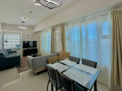 a living room with a table and a couch at 1 Bedroom Homestay in 8 Adriatico Manila in Manila