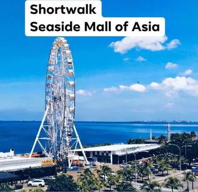 a large ferris wheel in a seaside mall of asahi at Shore Residence D23 shortwalk MOA in Manila