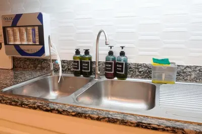 a kitchen sink with three bottles of wine at Makati Altean Apartment (Delfin Room) in Manila