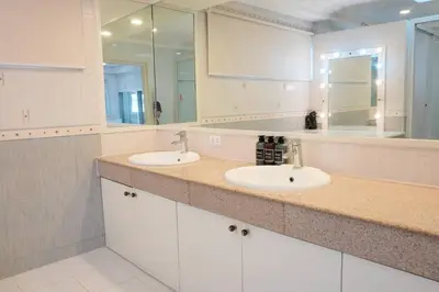 a bathroom with two sinks and a large mirror at Makati Altean Apartment (Delfin Room) in Manila