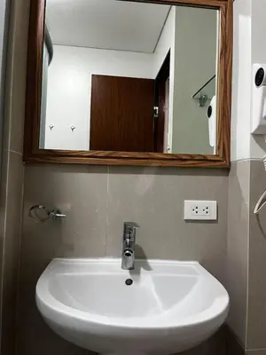 a white sink in a bathroom with a mirror at The Beacon Condo (1BR Unit) in Manila