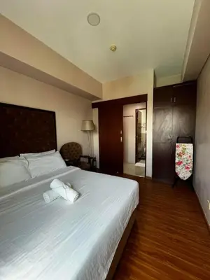 a bedroom with a large bed with white sheets at The Beacon Condo (1BR Unit) in Manila