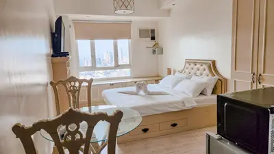 a bedroom with a bed with a table and a window at The Beacon Condo - Studio Tower 1 in Manila