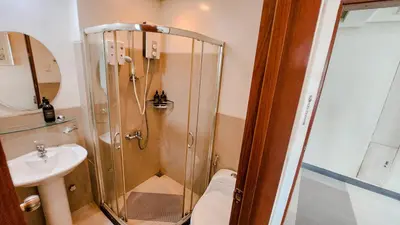 a bathroom with a shower and a toilet and a sink at The Beacon Condo - Studio Tower 1 in Manila