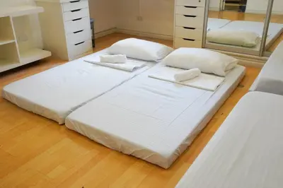 a large white bed in a room with a mirror at Makati Altean Apartment (Maura Room) in Manila