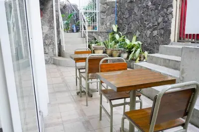 a row of tables and chairs on a patio at Makati Altean Apartment (Leonora Room) in Manila