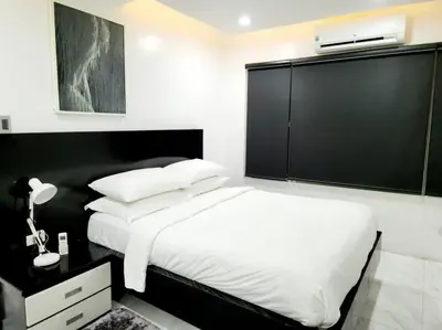 a bedroom with a white bed and a black wall at Alpha Grandview Malate Condo 2005 in Manila