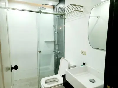 a bathroom with a shower and a toilet and a sink at Alpha Grandview Malate Condo 2005 in Manila