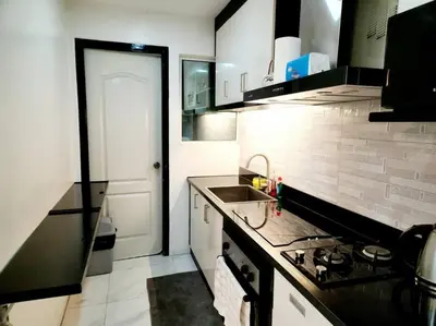 a small kitchen with a sink and a stove at Alpha Grandview Malate Condo 2005 in Manila