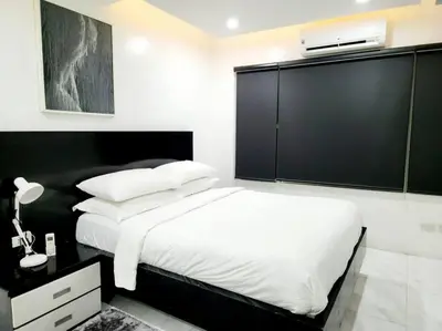 a bedroom with a white bed and a black wall at Alpha Grandview Malate Condo 2005 in Manila