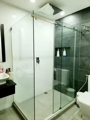 a glass shower in a bathroom with a toilet at Alpha Grandview Malate Condo 2005 in Manila