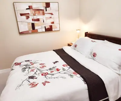 a bed with white sheets and red flowers on it at KL Tower Condo, Makati City in Manila