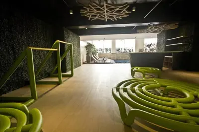 a large room with green chairs and a staircase at KL Tower Condo, Makati City in Manila