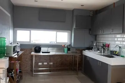 a kitchen with gray cabinets and a sink and a window at Maria Deck Urban Glamping in Manila