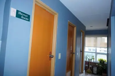 a hallway with an orange door with a street sign on it at Maria Deck Urban Glamping in Manila