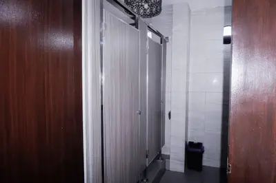 a bathroom with a hallway with a wooden door at Maria Deck Urban Glamping in Manila