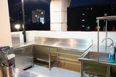 a stainless steel kitchen with a view of a city at Maria Deck Urban Glamping in Manila