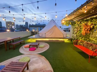 a tent on the roof of a building with green grass at Maria Deck Urban Glamping in Manila
