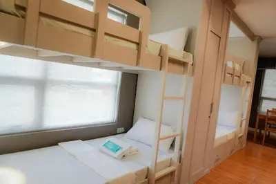 a bedroom with two bunk beds and a window at ALTEAN Apartments - Isabela Room in Manila