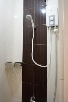 a shower with a shower head in a bathroom at ALTEAN Apartments - Isabela Room in Manila