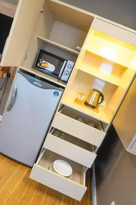 an open kitchen with a refrigerator and a microwave at ALTEAN Apartments - Isabela Room in Manila