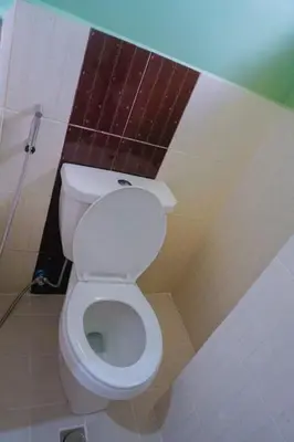 a bathroom with a white toilet in a stall at ALTEAN Apartments - Lourdes Room in Manila
